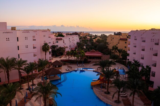 Vue de l'hôtel luxueux avec piscine et mer Rouge au lever du soleil