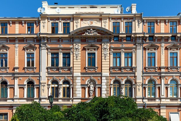 Une vue imprenable sur une façade vintage d'un immeuble avec des éléments décoratifs et des sculptures