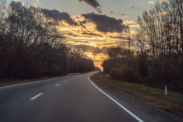 Vue imprenable avec forêt d'automne colorée avec route de montagne asphaltée Beau paysage avec des arbres de route vides et la lumière du soleil en automne Fond de voyage Nature