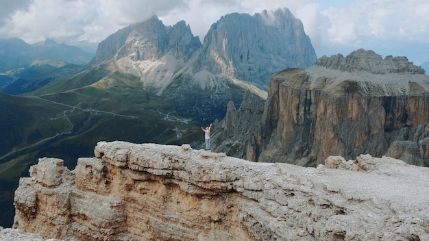 Vue Imprenable Sur Les Montagnes Avec Une Femme Debout Sur Le Dessus Avec Les Mains Tendues. Sentir La Liberté Et Profiter De La Nature.