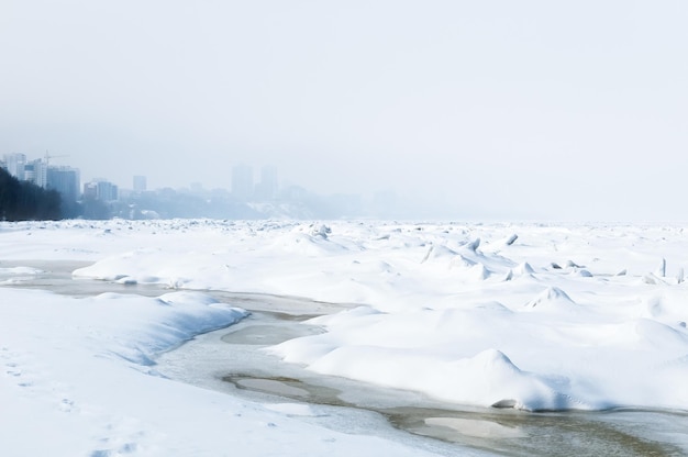 Vue imprenable sur la rivière gelée recouverte de morceaux de glace et de neige givrée blanche Désert enneigé