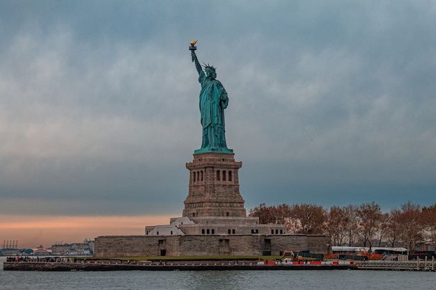 Vue imprenable sur la Statue de la Liberté contre le ciel sombre et nuageux