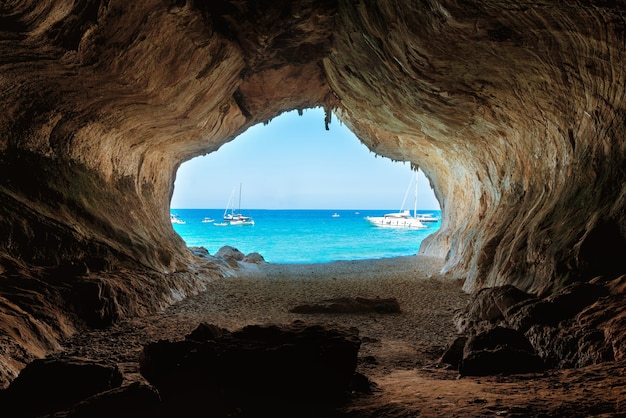 Vue de l'intérieur de la grande grotte sur la plage et la mer bleue. Côte méditerranéenne, Sardaigne, Italie.