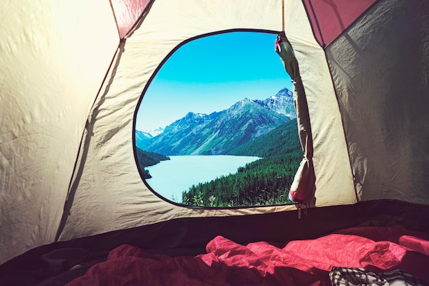 Vue de l'intérieur vers l'extérieur TentA jaune vue sur le lac Camping dans les bois Lac de montagne Kucherlinskoe d'en haut Altay Russie