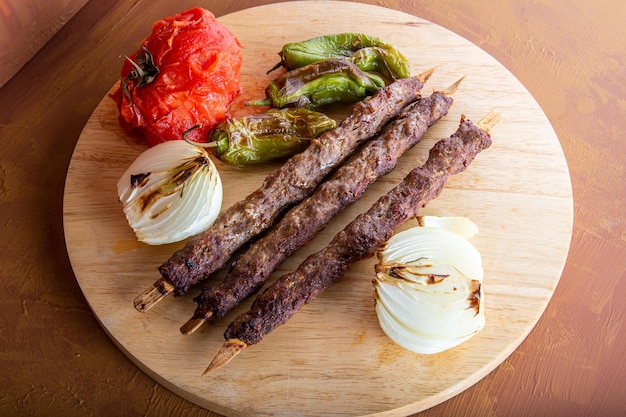 Vue de kebap d'Adana avec l'oignon de tomate et le poivron vert