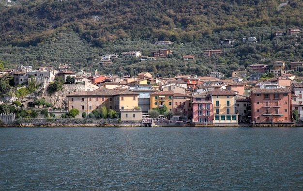 Une vue d'un lac avec un bateau au premier plan et un bâtiment sur la droite.