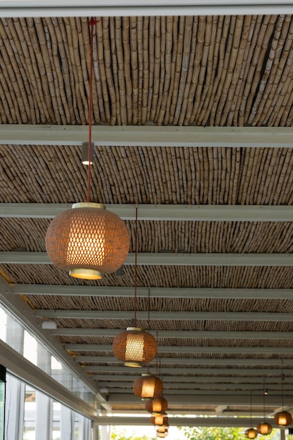 Vue des lanternes en bois suspendues à un plafond en bambou