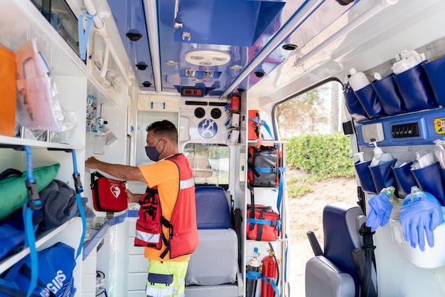 Vue large du sauveteur utilisant l'équipement à l'intérieur d'une ambulance