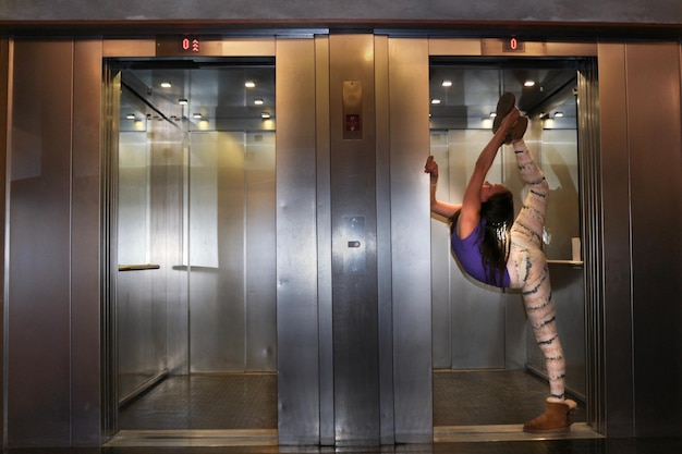 Photo vue latérale d'une adolescente faisant de l'exercice dans l'ascenseur