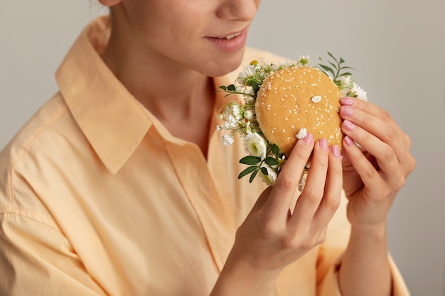 Photo vue latérale adulte tenant burger