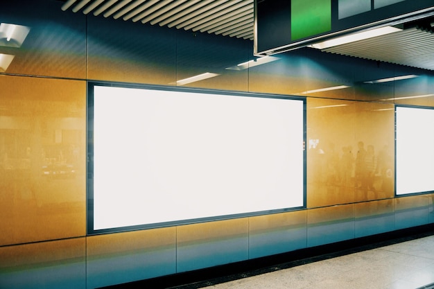 Vue latérale d'une bannière de métro blanche et propre sur un mur orange Publicité et concept urbain Maquette