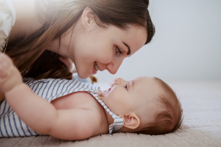 Vue latérale de la belle maman caucasienne parlant à son adorable petit garçon.