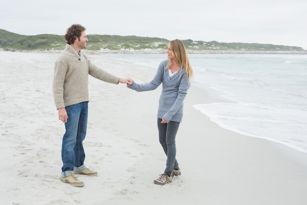 Vue latérale d&#39;un couple main dans la main sur la plage