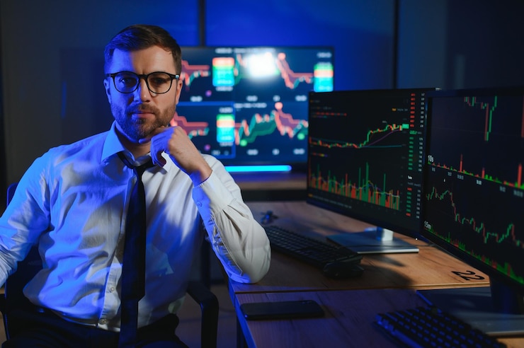 Photo vue latérale d'un courtier en crypto assis à une table de bureau analysant le marché en regardant l'écran