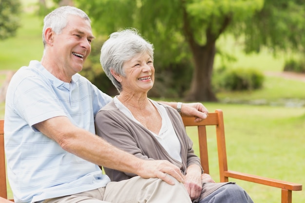 Vue latérale du couple âgé assis sur un banc au parc