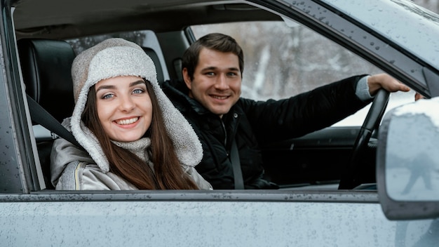 Vue latérale du couple smiley dans la voiture lors d'un road trip