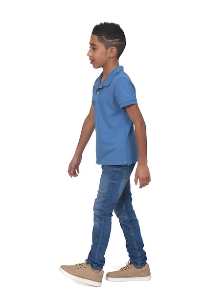 Photo vue latérale du garçon marchant sur fond blanc