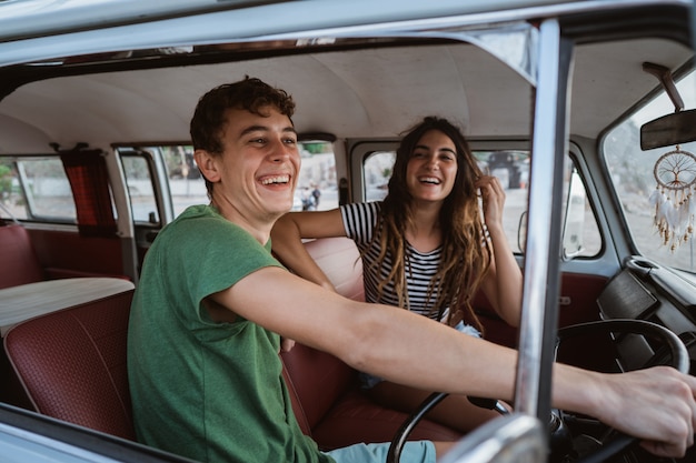 Vue latérale du jeune couple à l'intérieur de la voiture