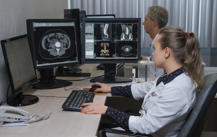 Photo vue latérale du jeune médecin travaillant sur ordinateur