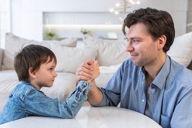 Vue latérale du père et du fils en compétition dans le bras de fer