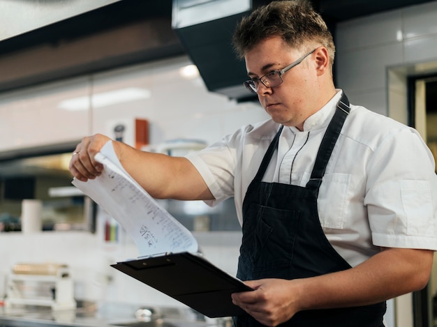 Photo vue latérale du presse-papiers de contrôle de chef masculin