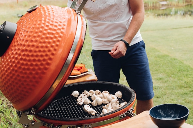 Vue latérale du processus de rôtissage des champignons sur le gril