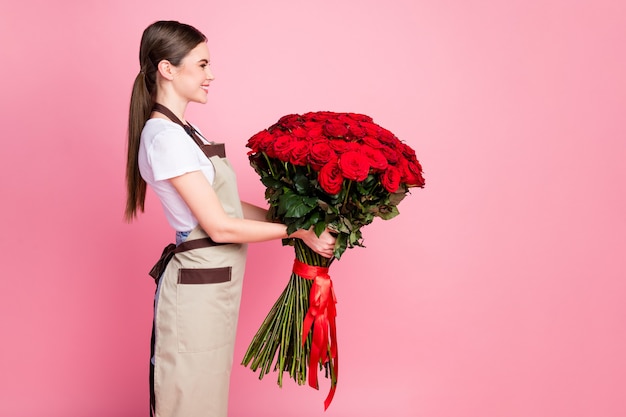 Vue latérale du profil portrait de jeune fille tenant dans les mains bouquet géant rose rouge