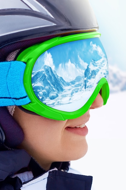 Vue latérale du snowboarder féminin sur la montagne avec de la neige