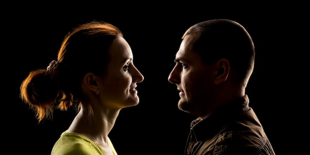 Vue latérale du visage de la femme et du visage de l'homme à l'envers sur fond noir