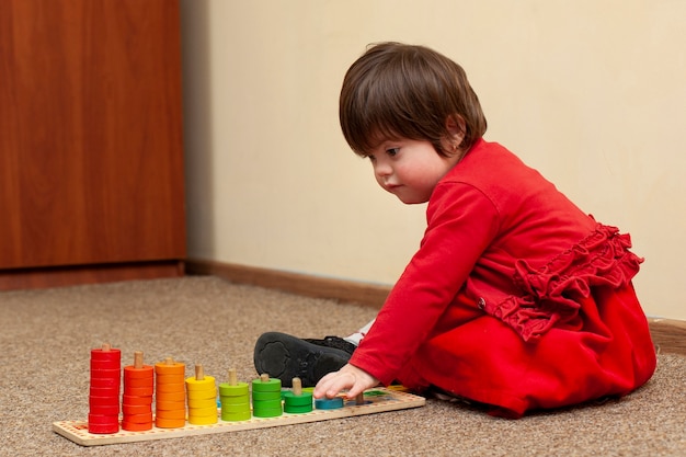 Vue latérale d'un enfant trisomique jouant