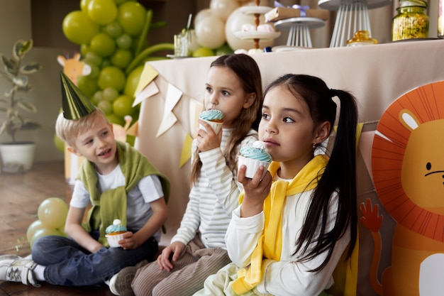 Photo vue latérale des enfants mangeant des cupcakes