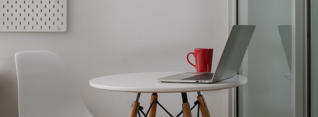 Vue latérale de l'espace de travail portable avec ordinateur portable, tasse à café et espace copie