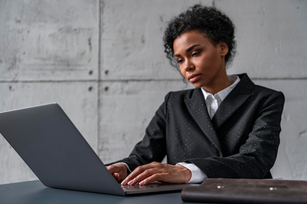 Vue latérale d'une femme africaine à la table de bureau