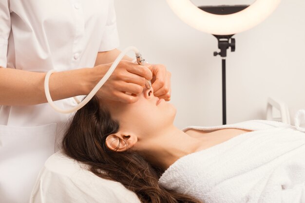 Vue latérale d'une femme allongée pour une procédure de beauté.