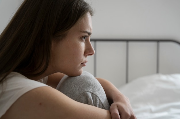 Vue latérale femme anxieuse au lit