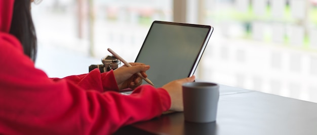 Vue Latérale De La Femme Dans Les Mains De Chandail Rouge Travaillant Avec Maquette De Tablette Numérique Au Café