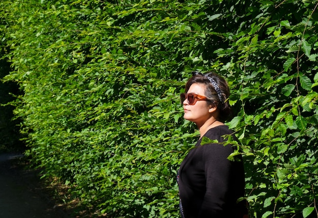 Photo vue latérale d'une femme debout contre des plantes