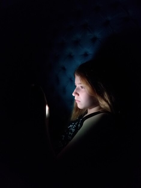 Photo vue latérale d'une femme debout sur un fond noir