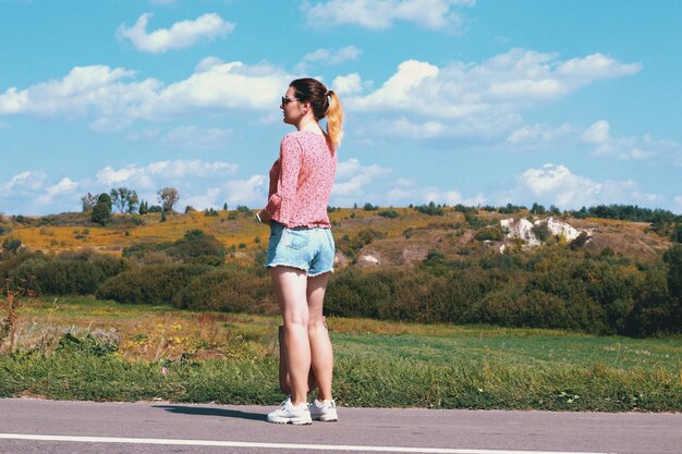 Photo vue latérale d'une femme debout sur la route contre le ciel