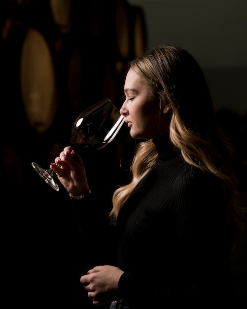 Vue latérale femme dégustant un verre de vin