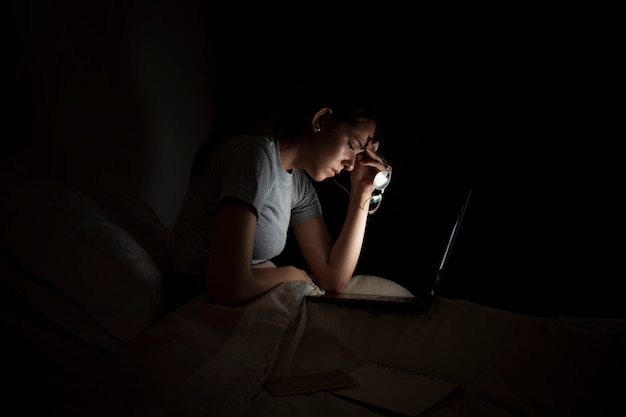 Photo vue latérale d'une femme fatiguée travaillant tard à la maison