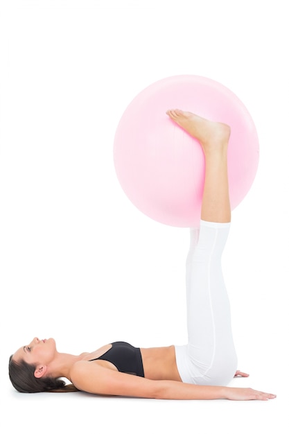 Vue latérale d&#39;une femme en forme avec ballon de fitness