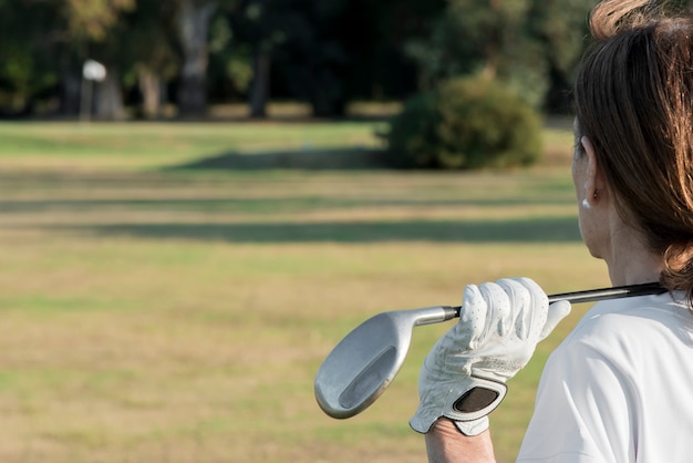 Photo vue latérale femme jouant au golf