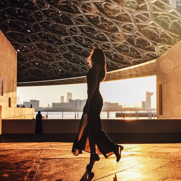 Photo vue latérale d'une femme marchant dans un bâtiment