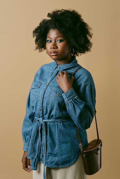 Photo vue latérale femme noire qui pose en studio