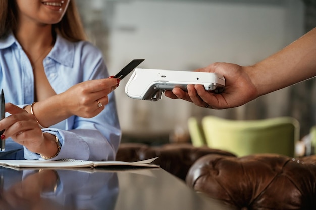 Vue latérale Une femme paie pour le service dans le restaurant