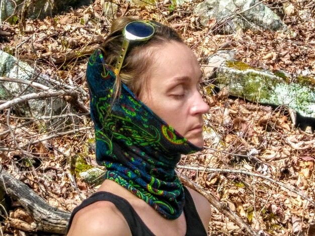 Photo vue latérale d'une femme portant un foulard dans la forêt