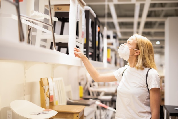 Vue latérale d'une femme portant un masque debout dans un magasin