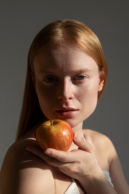 Vue latérale femme posant avec pomme fraîche