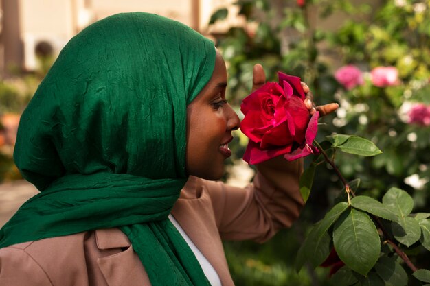 Photo vue latérale femme sentant la fleur